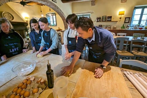 A family making pasta together at the tuscan cooking class of Podere Spedalone!