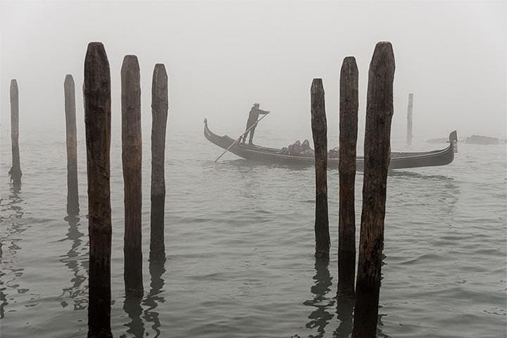 A solitary Gondola riding in the fog