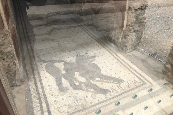 Pompeii - The famous mosaic of the dog on a chain with the Latin inscription "Cave Canem" which stands for "Be Aware of the Dog"