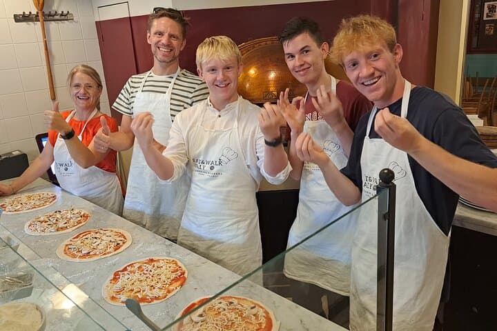 Happy guests with their own pizzas!