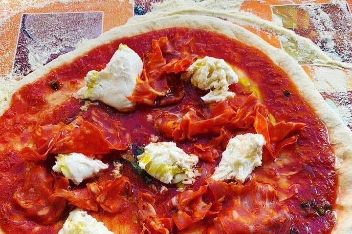 Pizza base with tomato sauce, mozzarella cheese and salami