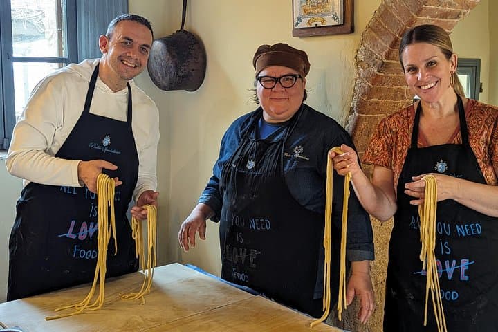 A family making pasta together at the tuscan cooking class of Podere Spedalone!