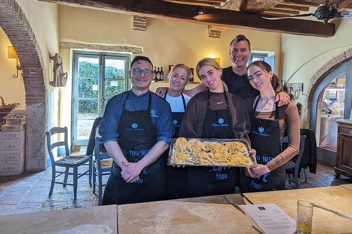 A family making pasta together at the tuscan cooking class of Podere Spedalone!