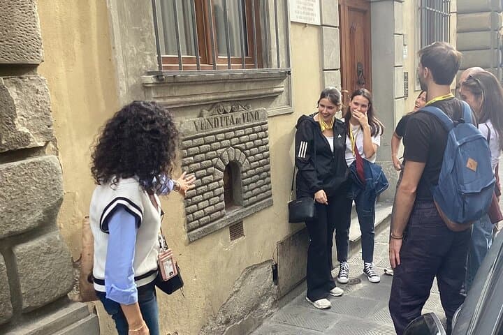 Guide showing visitors an historical Wine Window in the center of town