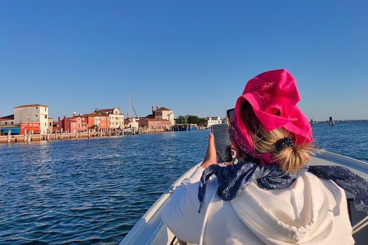 Women taking pictures of Pellestrina Island during boat experience