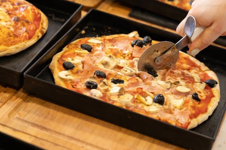 Slicing the pizza fresh from the oven.