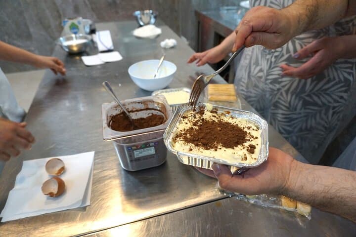 Putting cocoa on top of tiramisù.