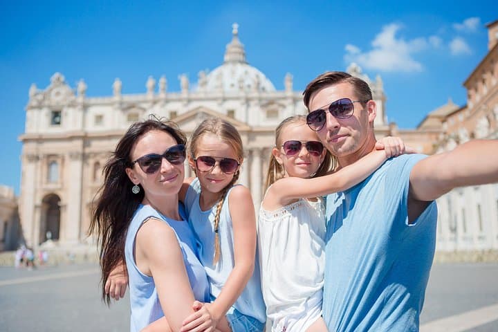 Happy family posing in front of St. Peter’s Basilica in Vatican City, enjoying our guided tour of one of Rome’s most iconic landmark