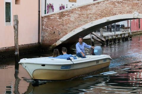 Couple in love while sailing aboard a typical lagoon boat in Canal Vena Chioggia