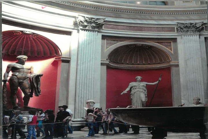 The Round Room in the Vatican Museums features impressive ancient Roman statues and a massive red porphyry basin, echoing the grandeur of the Pantheon.